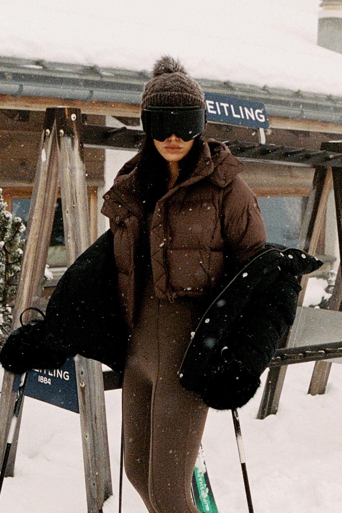 WISKII Cropped Convert Down Jacket in black, featuring a hood and quilted design, displayed on a hanger.