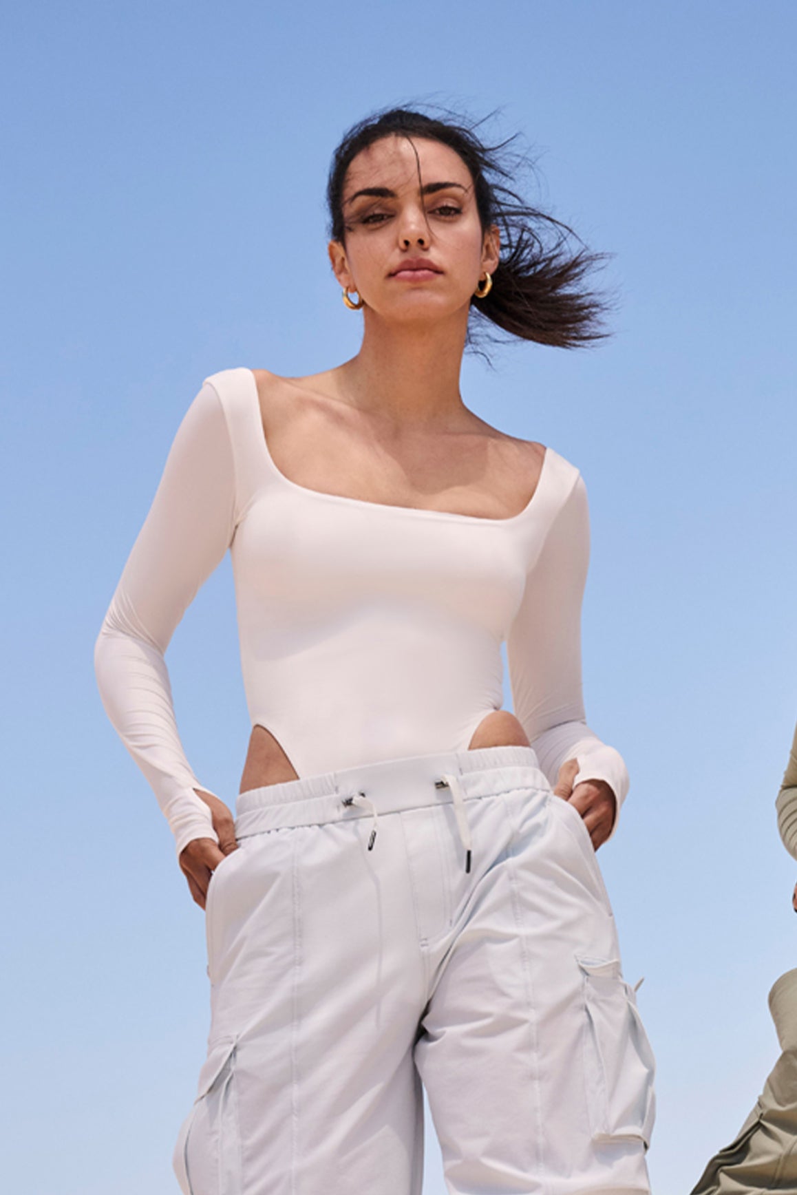 WISKII ivory scoop neck long sleeve bodysuit displayed on a mannequin, showcasing its fitted design and soft fabric.
