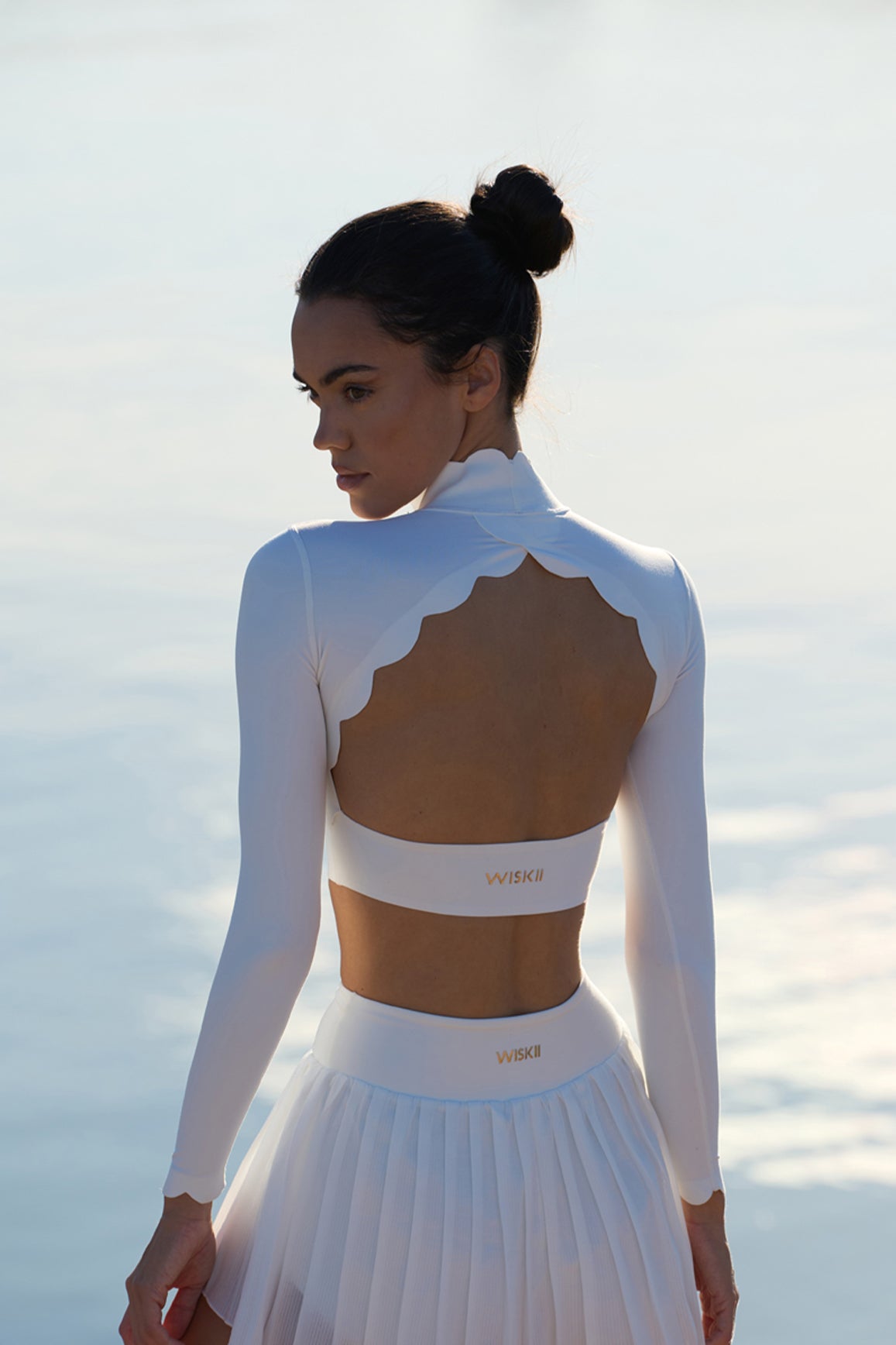 Model wears WISKII Open Back Long Sleeve Crop Top