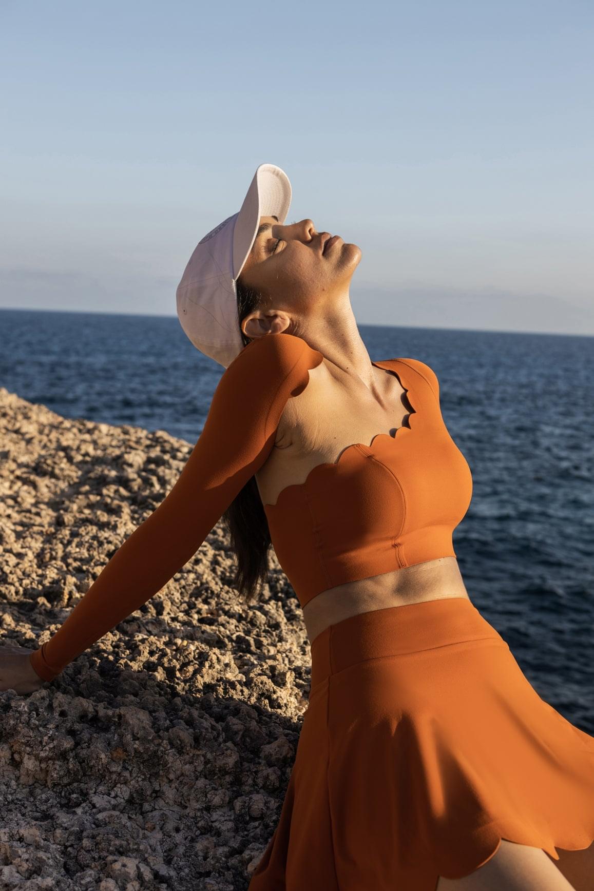 WISKII 不對稱長袖短版上衣,夕陽橘色,設計時尚且具獨特下擺,非常適合休閒或潮流穿搭。