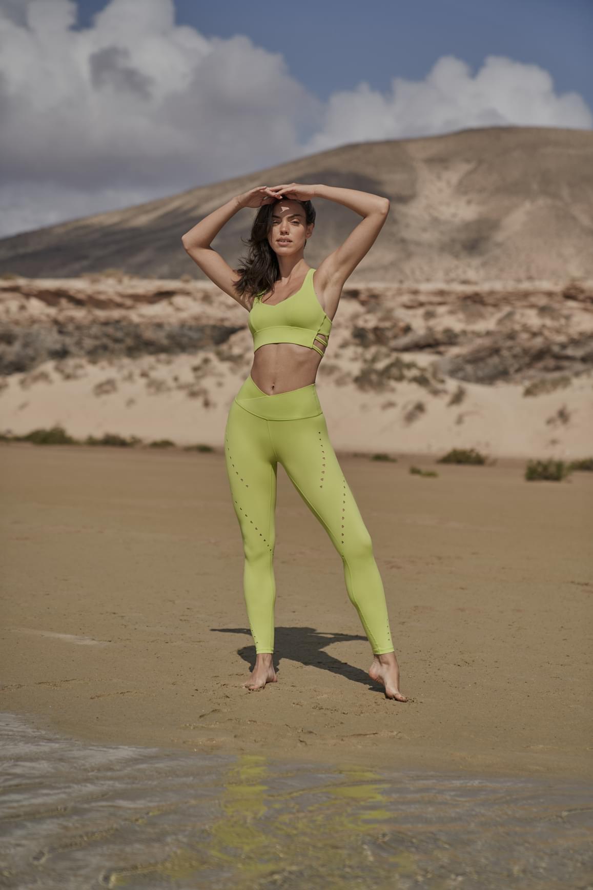 Ivory V-waist laser cut sports leggings by WISKII, featuring sleek cutout details and stretchy athletic fabric.