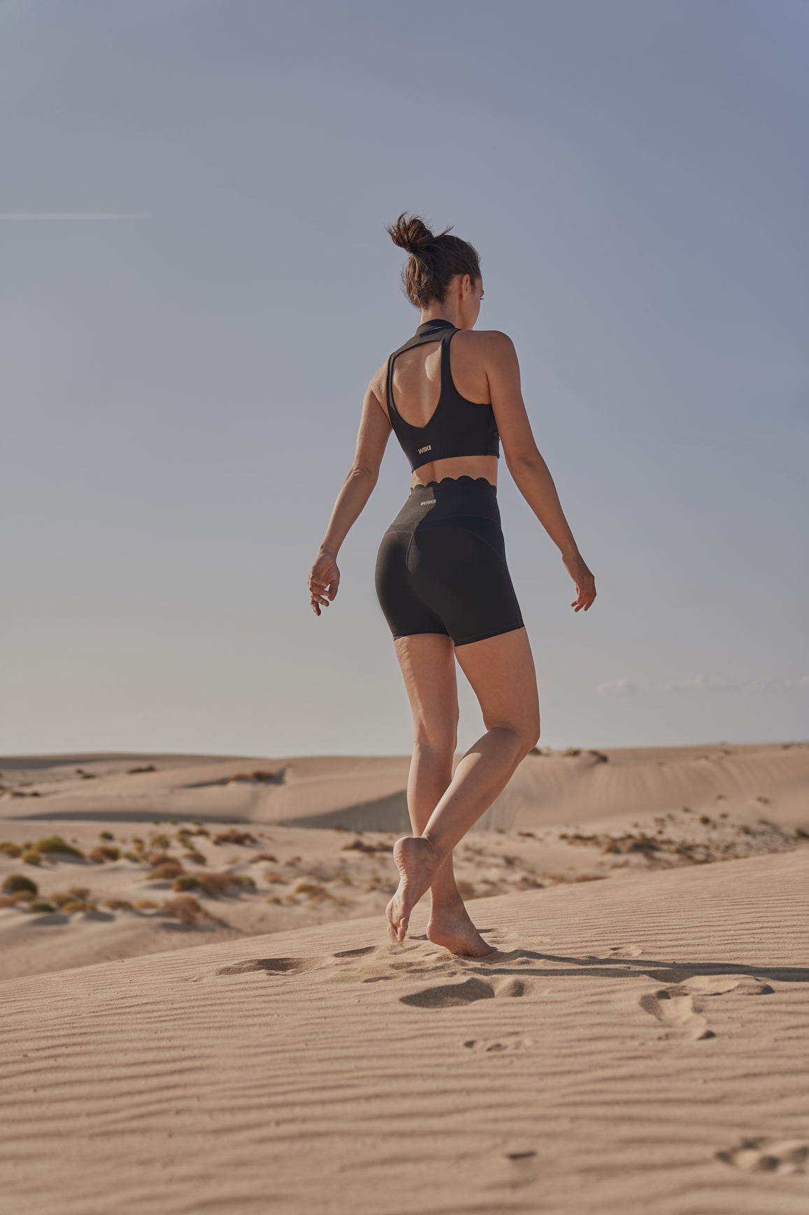 Black WISKII high-waist sculpting biker shorts displayed on a model, emphasizing their fitted and stretchy design.