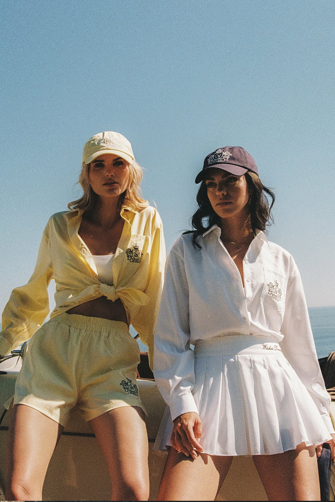 WISKII Riviera pleated skirt in high-waist cotton, shown in a summer cloud print with pleats and a flowing silhouette.