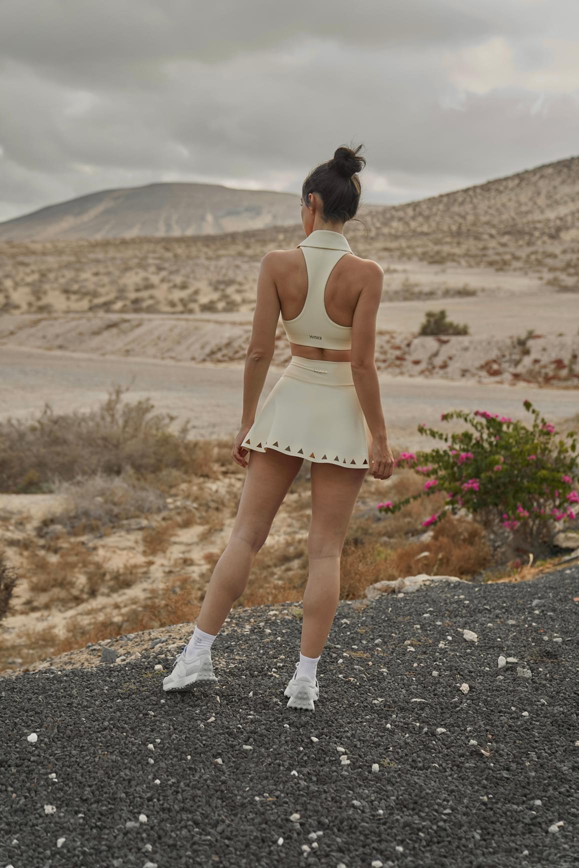 Ivory V-waist laser cut tennis skirt by WISKII, featuring a stylish, breathable design perfect for activewear and tennis matches.