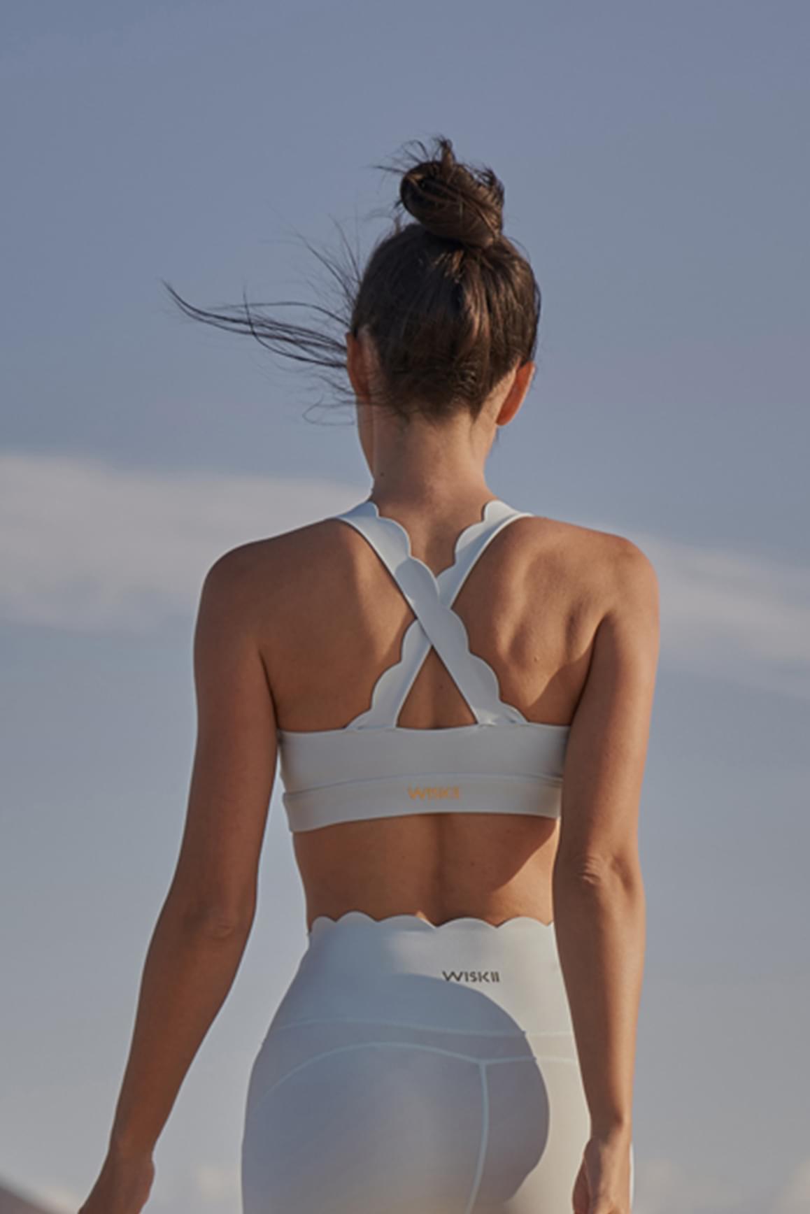 Ivory WISKII Cross Back Sports Bra showing the supportive front and stylish cross-back design for active wear.