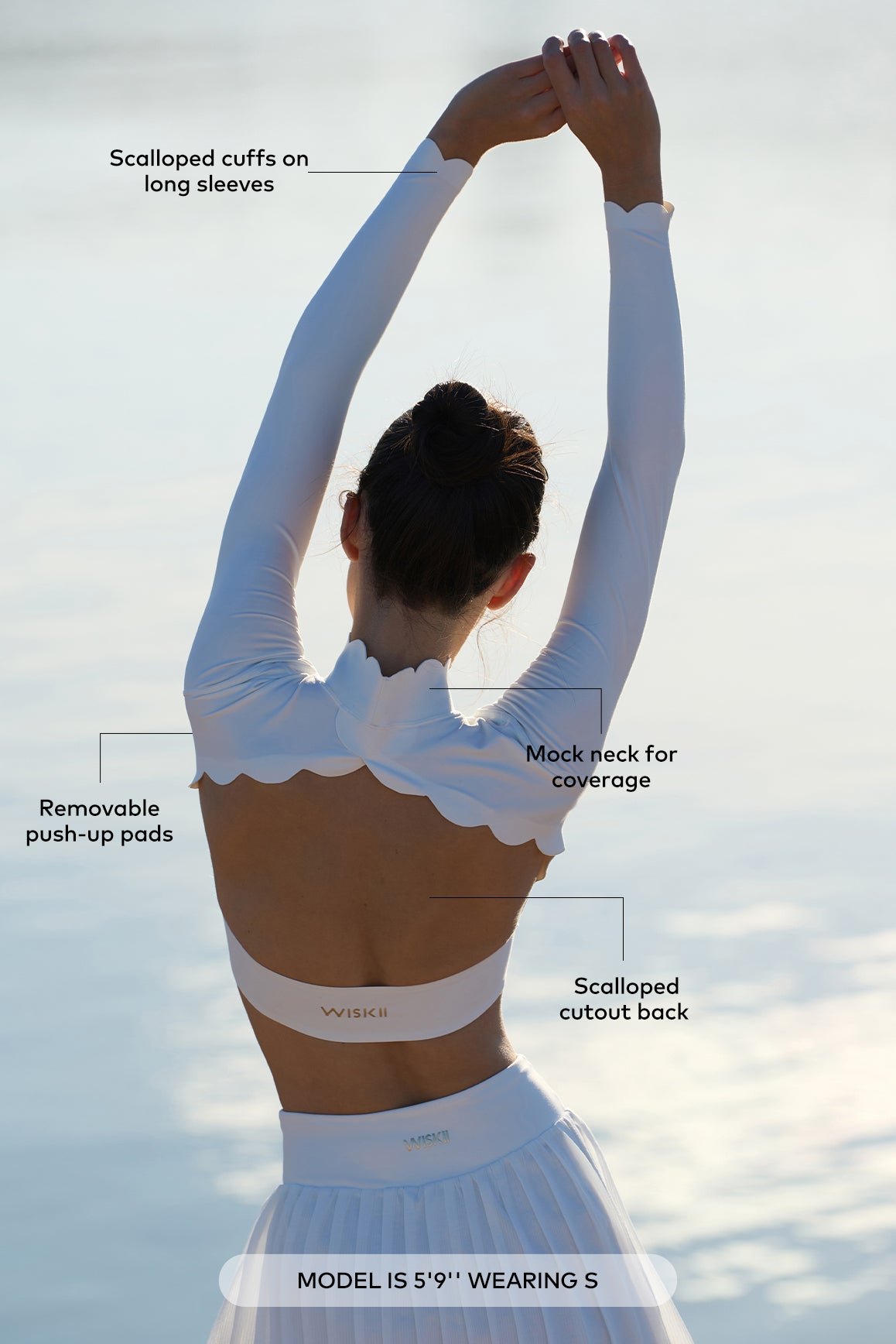 WISKII open back long sleeve crop top in black, showing its fitted style and stylish open back design.