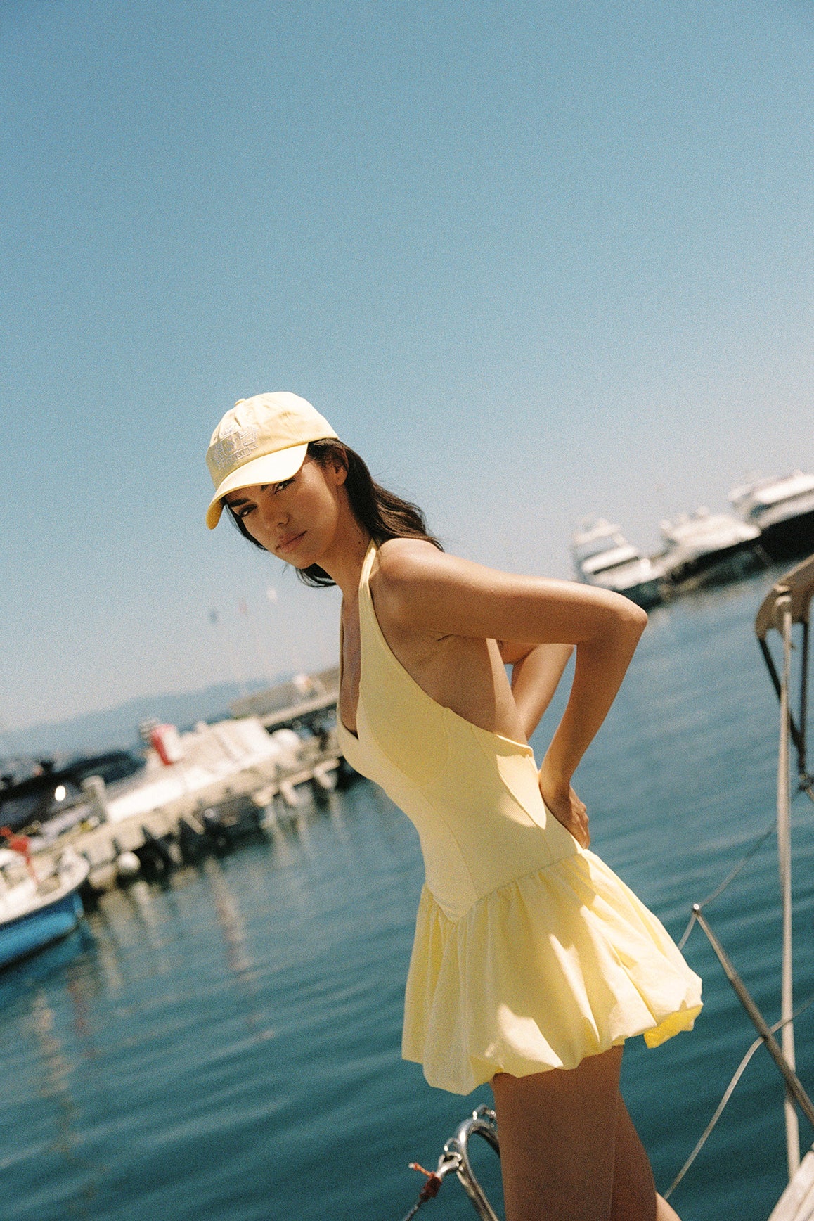 Model wears a Riviera Floral Backless Halter Dress | Lemon Drop | WISKII Active