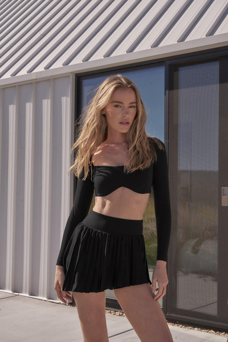 model wears a WISKII Lite Pleated Skirts