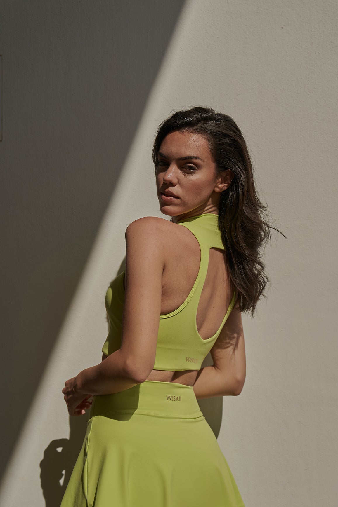 WISKII Diamond Cutout Mock Neck Sports Bra in Bitter Lime with stylish cutout design and supportive fit.