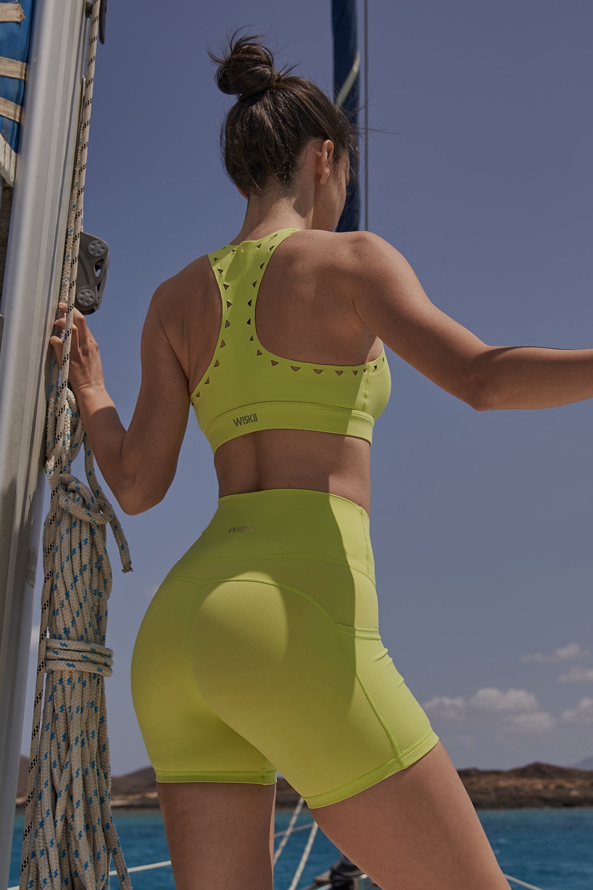WISKII Racerback Laser Cut Sports Bra in Bitter Lime with breathable laser-cut design and supportive fit.