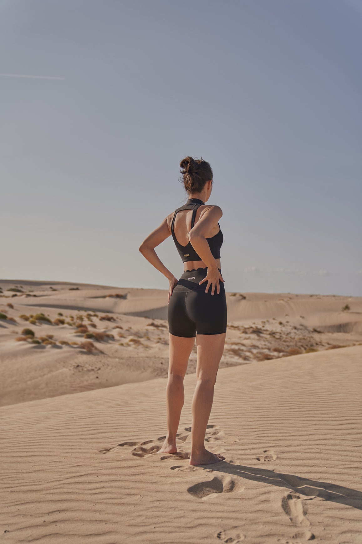 Black WISKII sports bra with diamond cutout mock neck design, featuring a fitted style and supportive structure.
