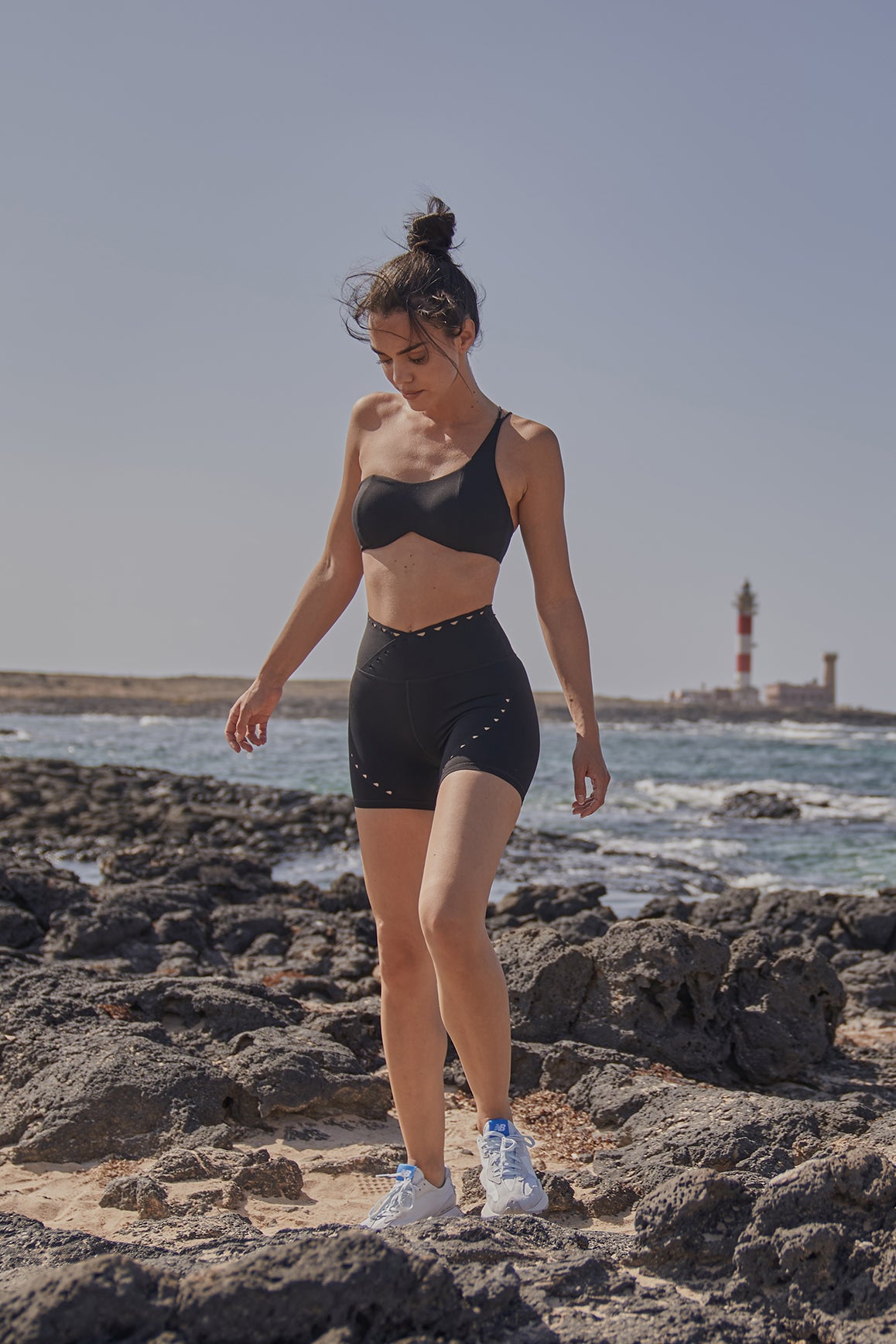 Black WISKII sports bra with one shoulder contour design, featuring supportive fit and sleek style for active wear.