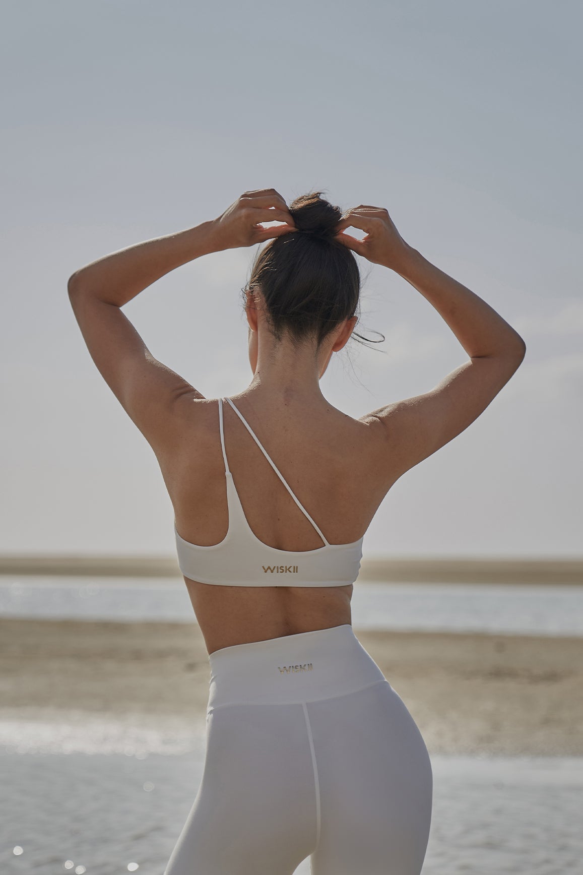 Black WISKII one shoulder contour sports bra with supportive fit and sleek design for active wear.