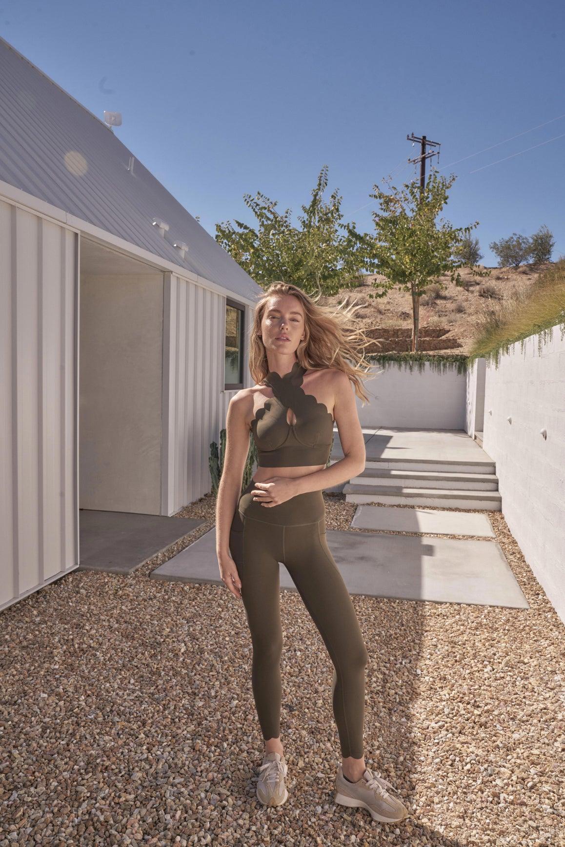 WISKII Crisscross Sports Bra in forest green with adjustable straps and crisscross back design, ideal for active wear.